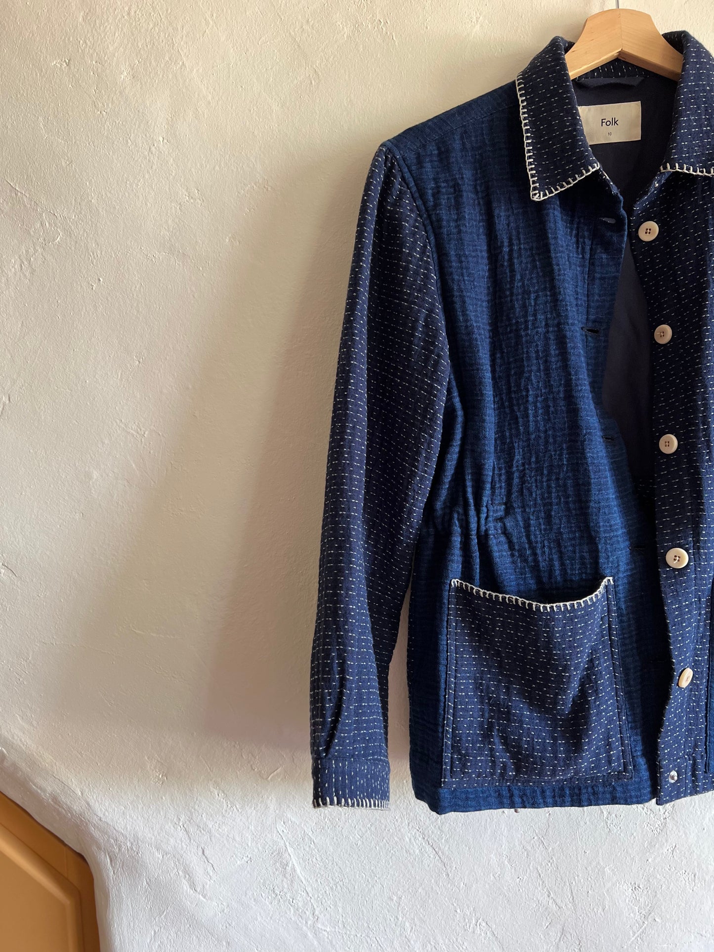 Folk Indigo Sashiko Waffle Patch Jacket hung against a white wall
