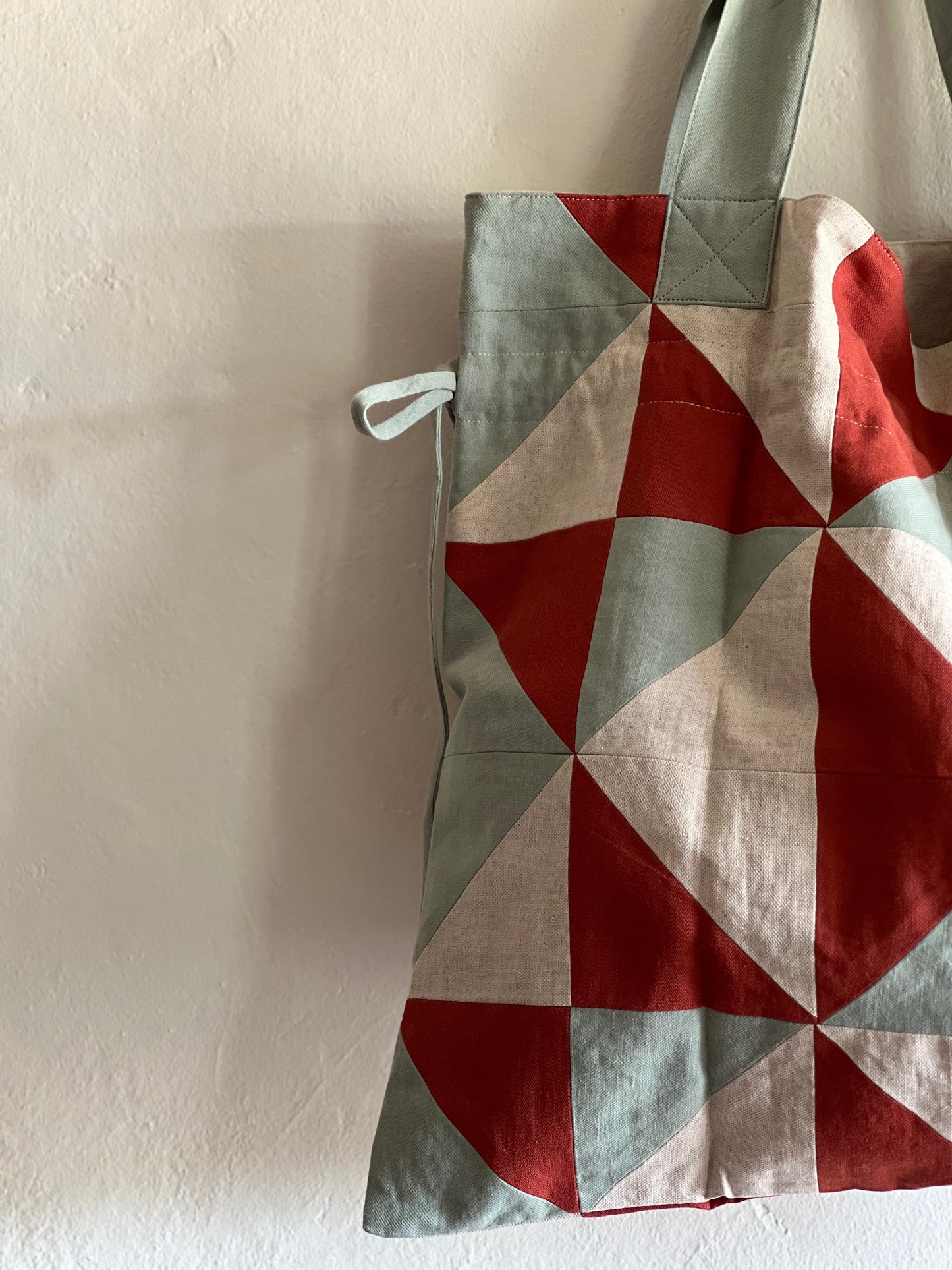 Sideline Cora Patchwork Bag hanging against a white wall