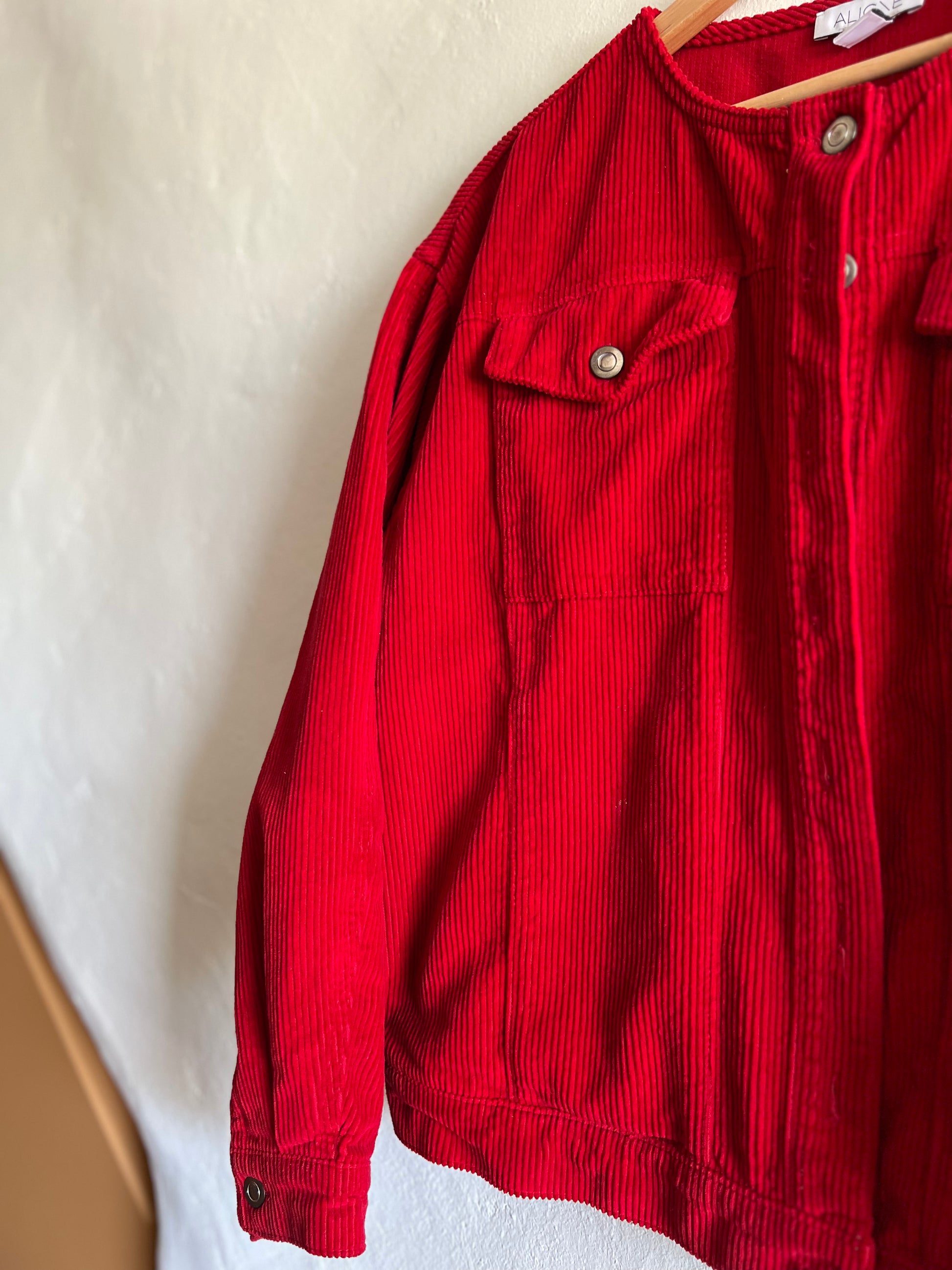 Aligne Red Cord Moto Jacket hanging against a white wall 