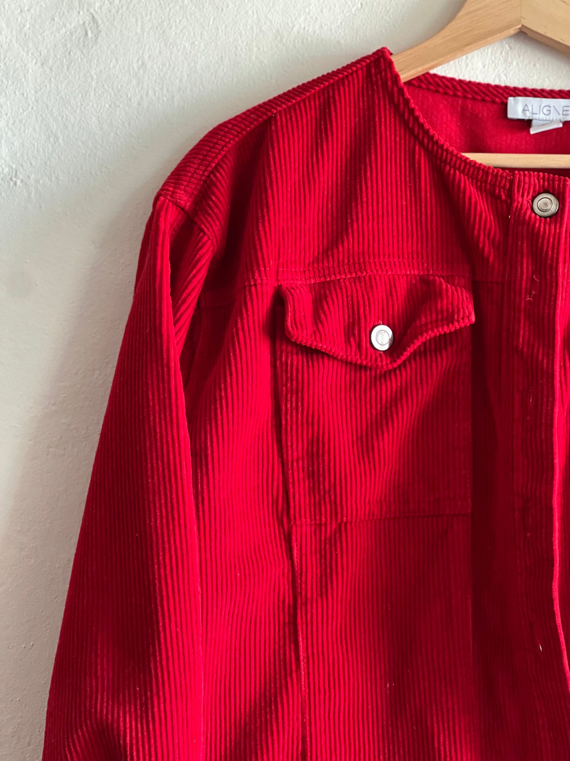 Aligne Red Cord Moto Jacket hanging against a white wall 
