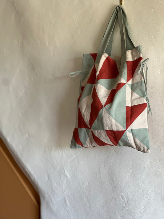 Sideline Cora Patchwork Bag hanging against a white wall 