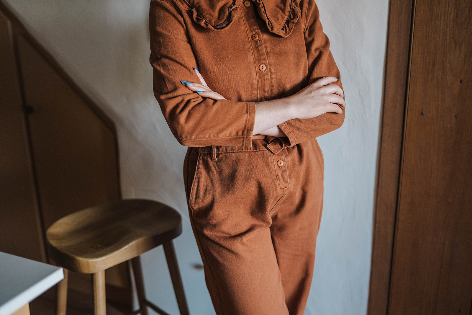 The Tiny Big Sister Rust Oversize Ruffle Collar Jumpsuit worn on model 