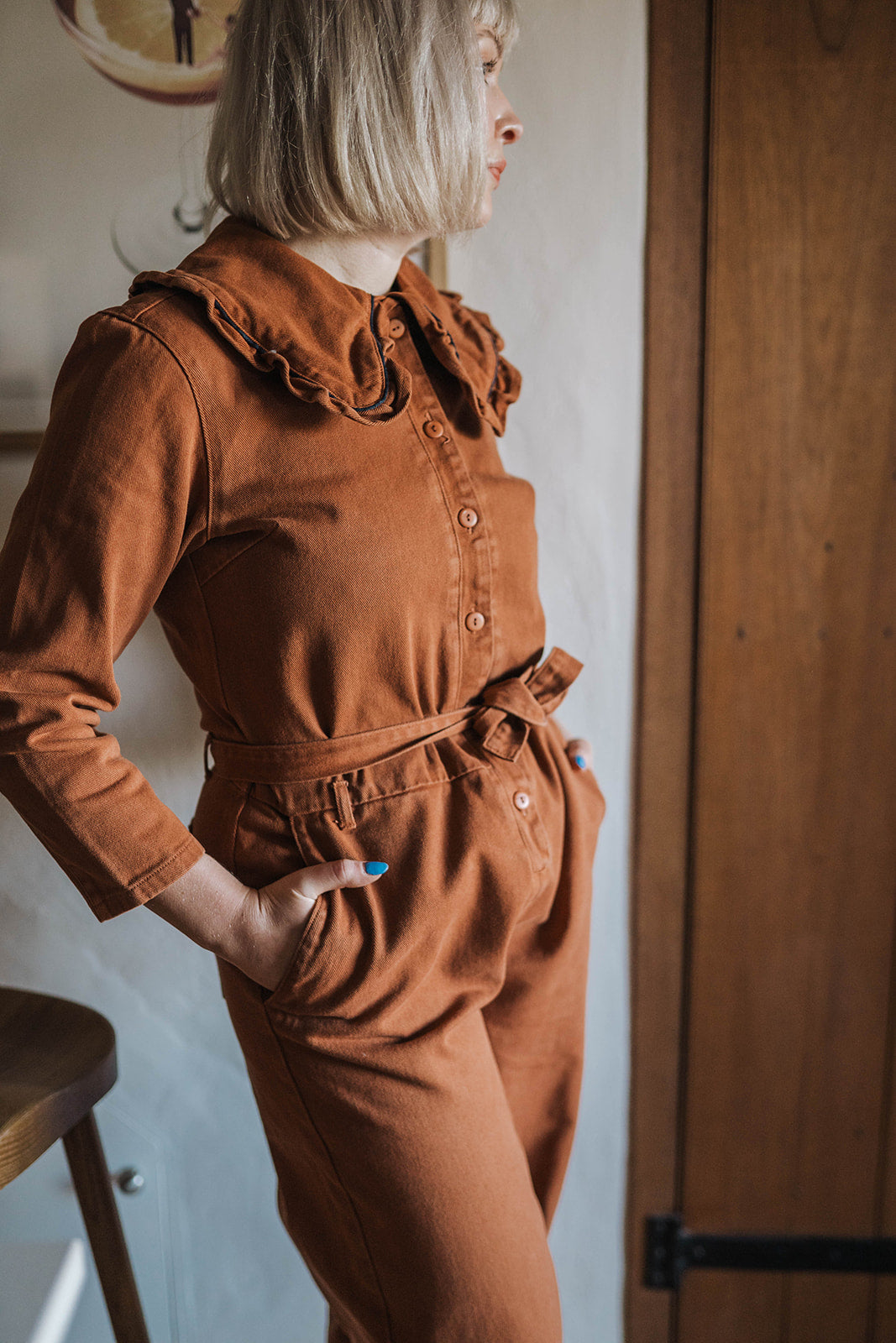 The Tiny Big Sister Rust Oversize Ruffle Collar Jumpsuit worn on model 